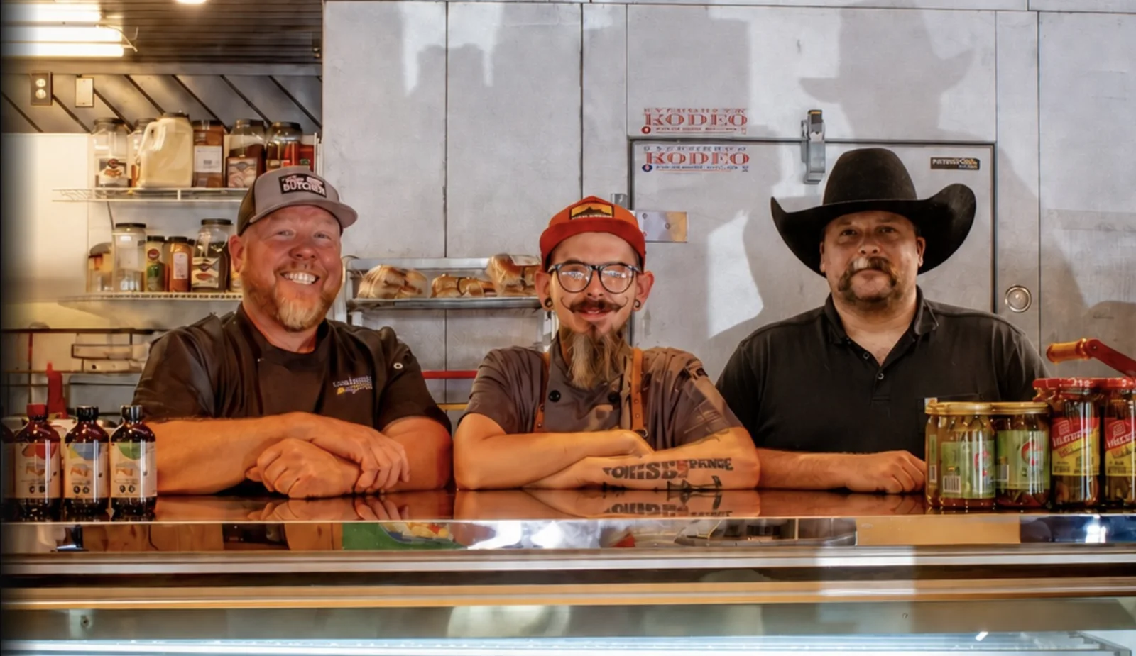 The Lazy Butcher crew gathered at the butcher case in Evergreen