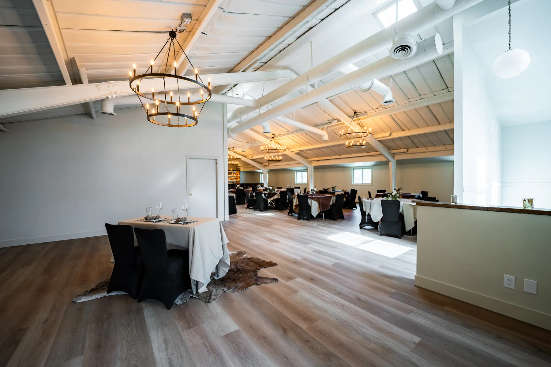 Heritage Hall's full banquet hall with vaulted ceilings, chandeliers, and tables set for a private event.