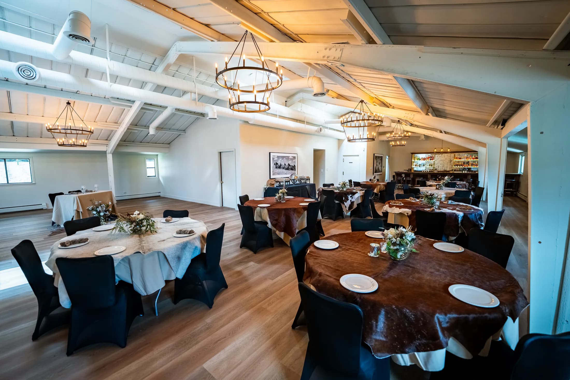 Heritage Hall reception room set with round tables, linens, and the Velvet Brim bar.
