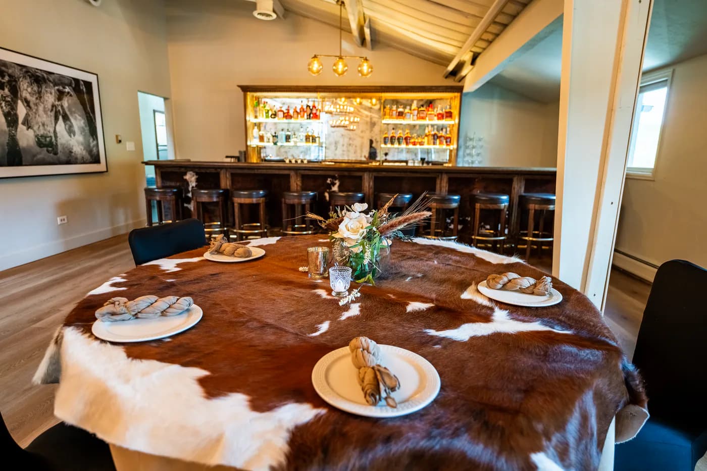 Round dining table at Heritage Hall set with a cowhide runner and place settings.